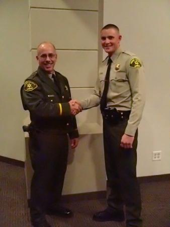 Sheriff Obenberger congratulating Deputy Hoskin